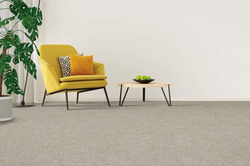 Grey carpet flooring in an open room with a yellow armchair