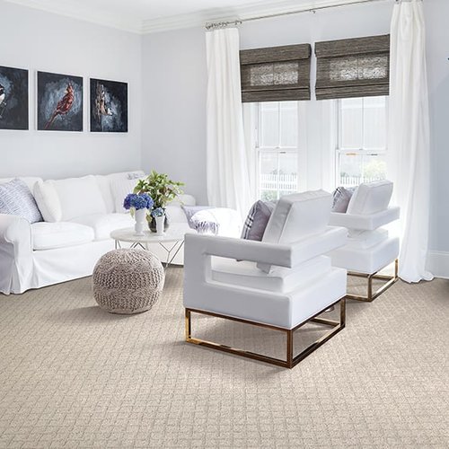 Patterned beige carpet in a coastal style home with a white sofa and chairs