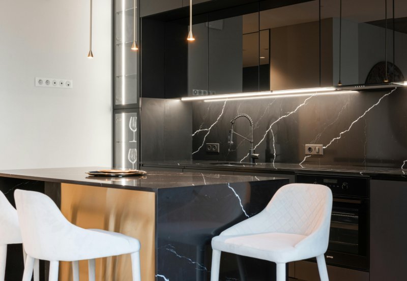 Modern kitchen with black marble counters and backsplash