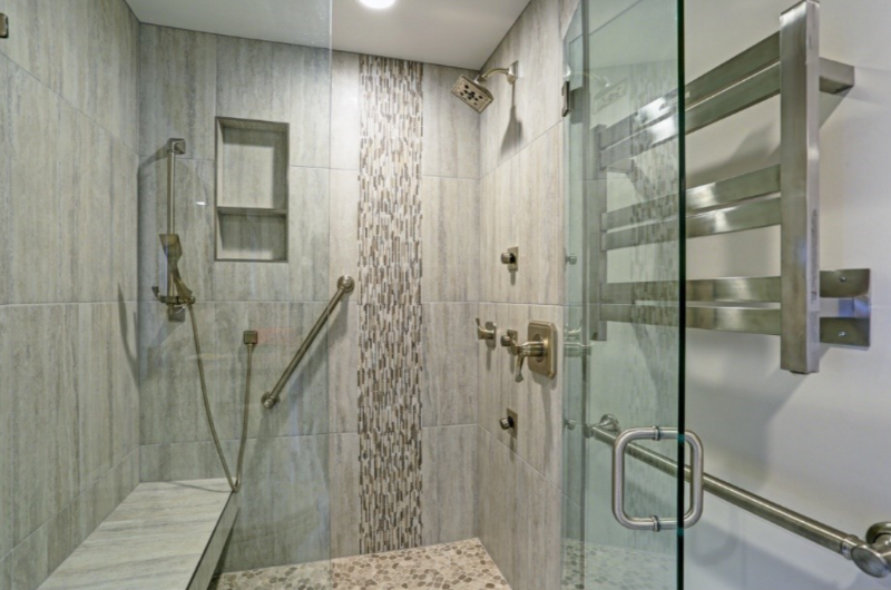 Accessible shower with patterned tiles, seat and safety bars