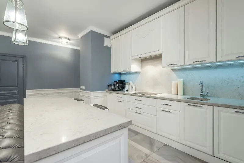 Granite countertop in a compact kitchen with white cabinets